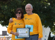 George's family wearing yellow "Miles for Meso" shirts while holding up a certificate that reads "Top Fundraising Team"