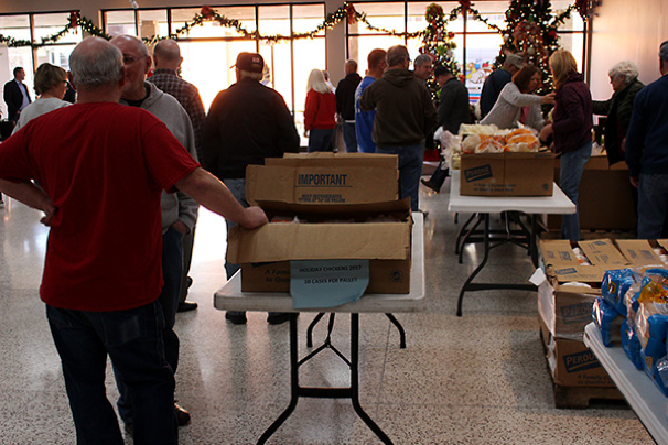 Volunteers begin to set up the assembly line for food baskets.
