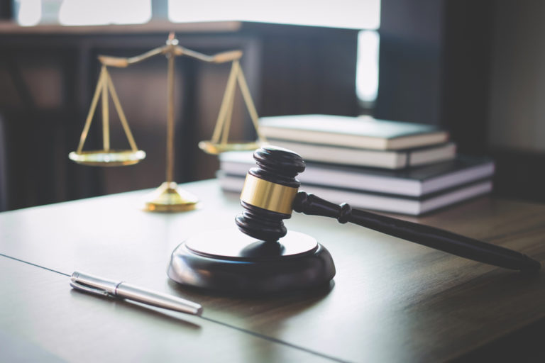 Legal scales of justice and a gavel on a lawyer's desk