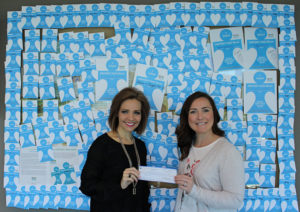Two women from the SHC Foundation hold a check