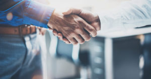 Two people shaking hands in a legal setting