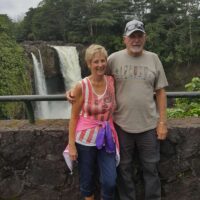 John Stahl and his wife stand together in front of a waterfall