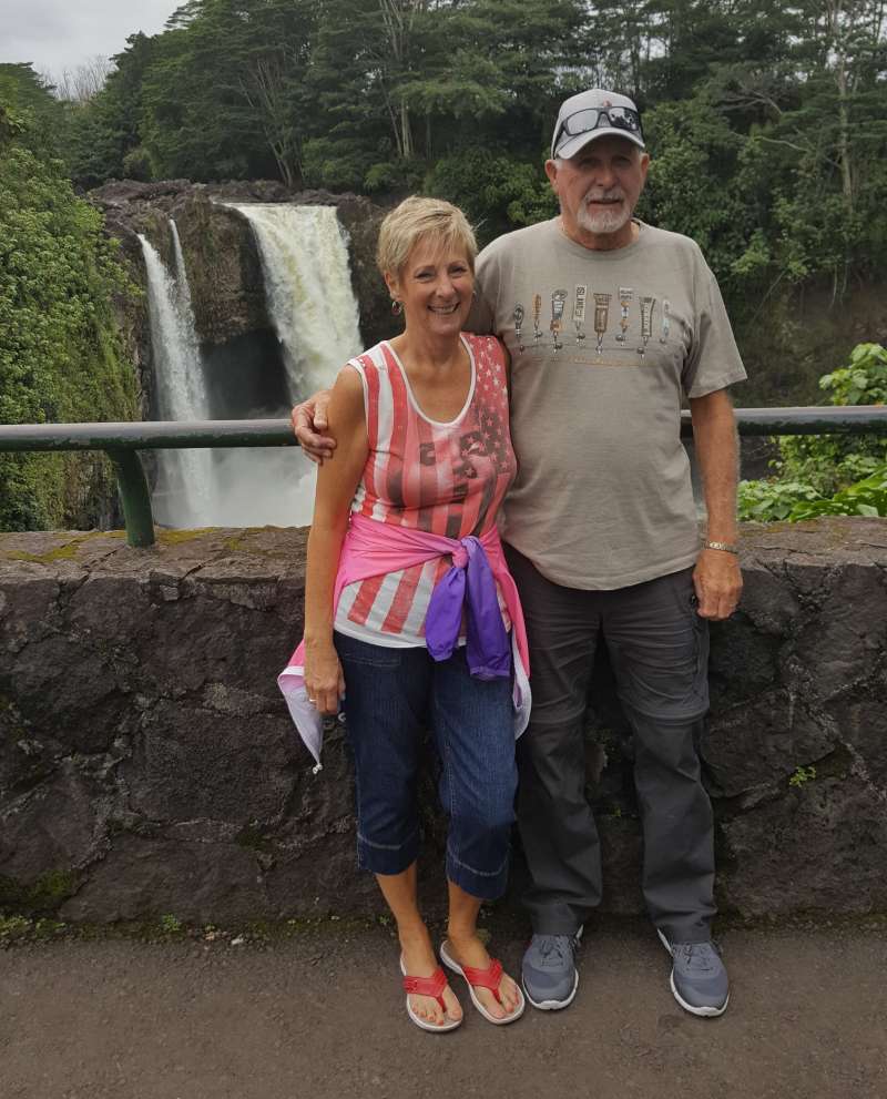 John Stahl and his wife stand together in front of a waterfall