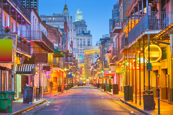 New Orleans city street at night, brightly lit by the shops along the road