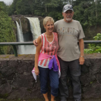 John Stahl and his wife stand together in front of a waterfall