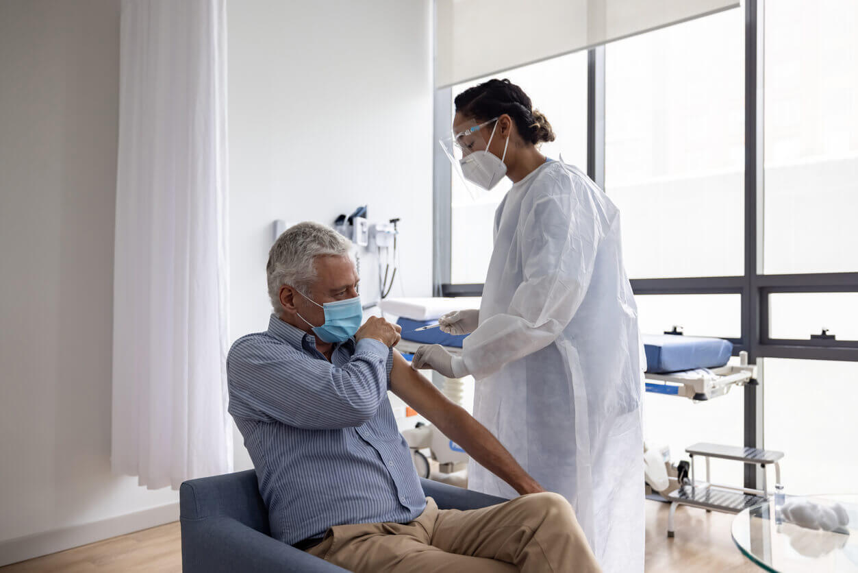 A patient rolls up his sleeve for the doctor