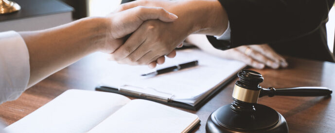 Lawyer shaking hand with a client at their desk
