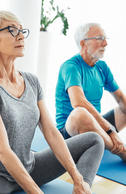 An older couple does yoga side by side