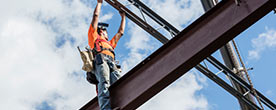 Construction worker standing on a support beam