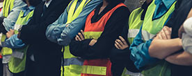 Workers in bright orange and yellow vests