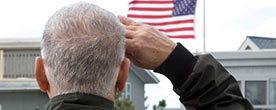 Veteran saluting an American flag