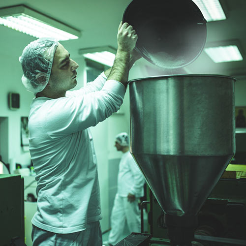 A worker dumps talc into a vat